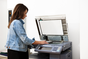 Woman standing and using a copy machine