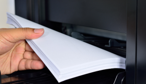 hand placing paper in copier tray