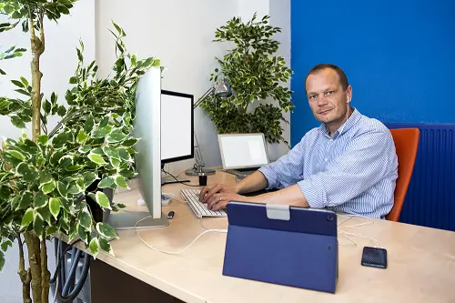 man sitting at a computer in a green paperless office