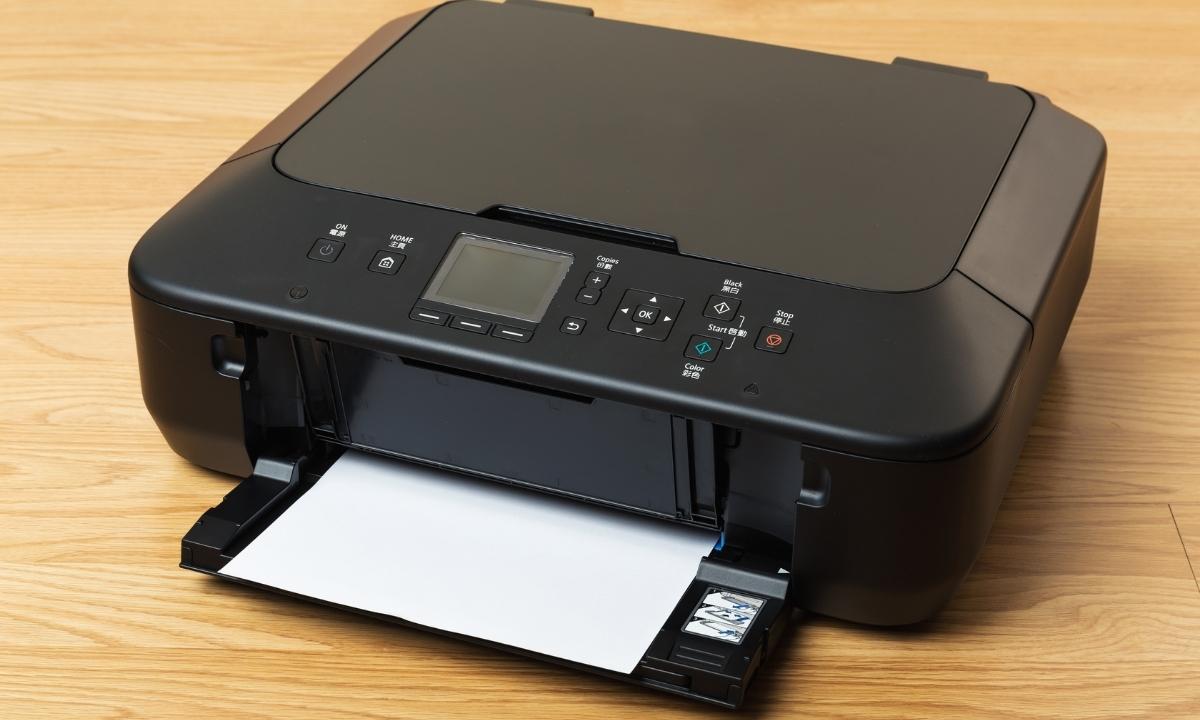 Black desktop printer on a wooden table